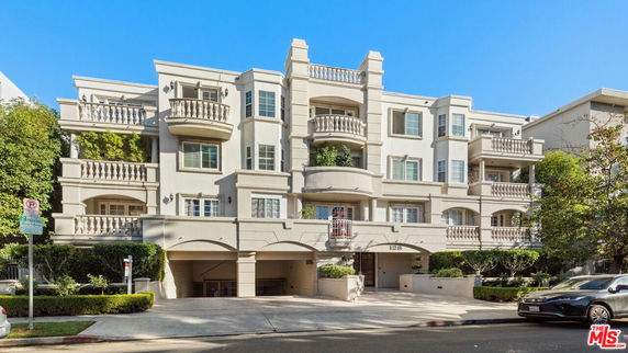 Front view of a multi-story apartment building with balconies.