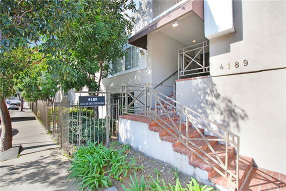 Front view of a townhouse entrance with stairs and metal railing.