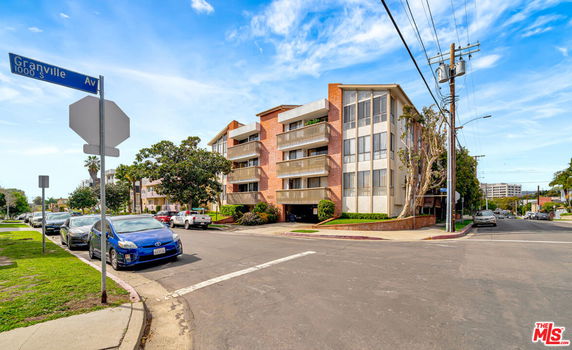 Front view of a multi-story residential building on a street corner.