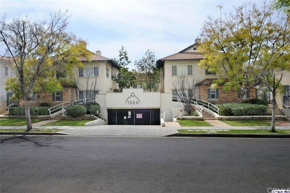 Front view of a multi-story residential building with parking entrance.
