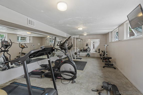 Indoor gym area with exercise equipment such as treadmills, bikes, and weights.