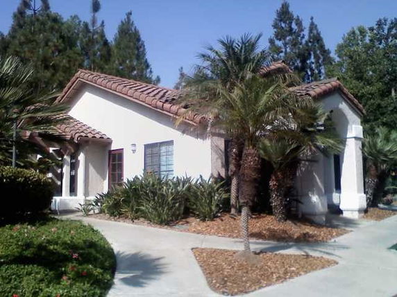 Front view of a single-story house with a tiled roof and a small garden.