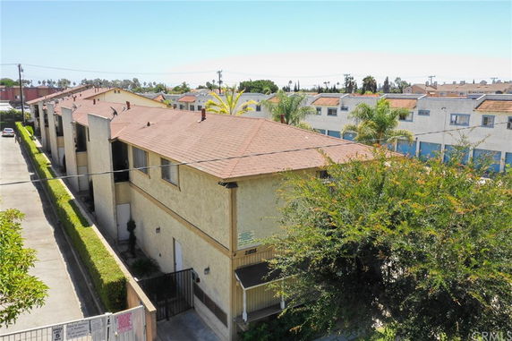 View of a row of connected residential buildings with sloped roofs.
