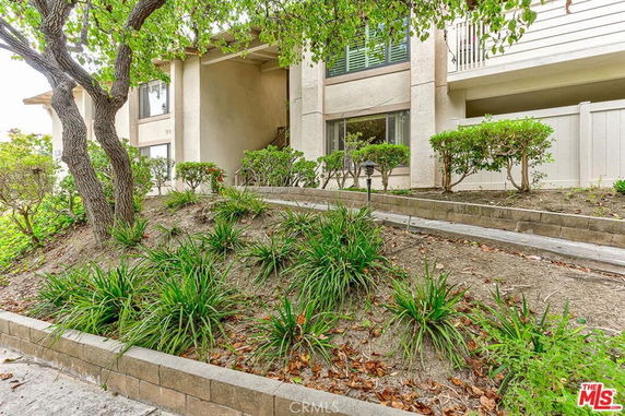 Front view of a multi-story residential building with balconies and landscaping.