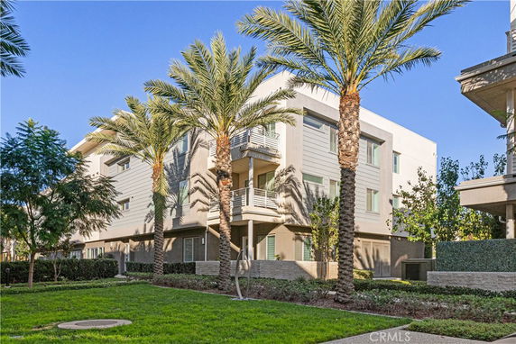 Front view of a multi-story modern building with large windows and balconies.
