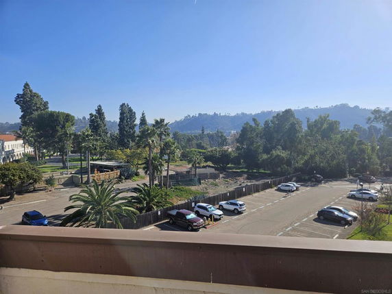 View of surrounding areas with trees and distant hills from a higher vantage point.