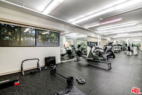 Indoor gym area with exercise equipment and mirrored walls.