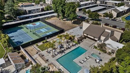 Aerial view of tennis courts and swimming pool in a residential area.
