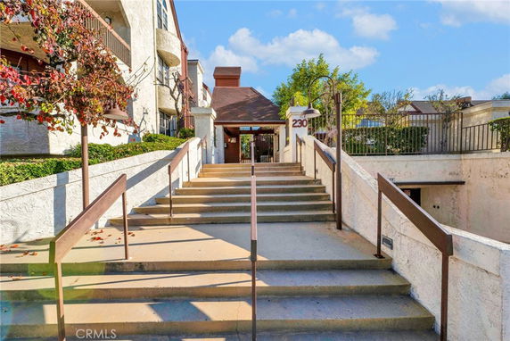 Front view of a multi-story building with stairs leading to the entrance.