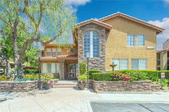 Front view of a two-story house with decorative stone facade and symmetrical windows.