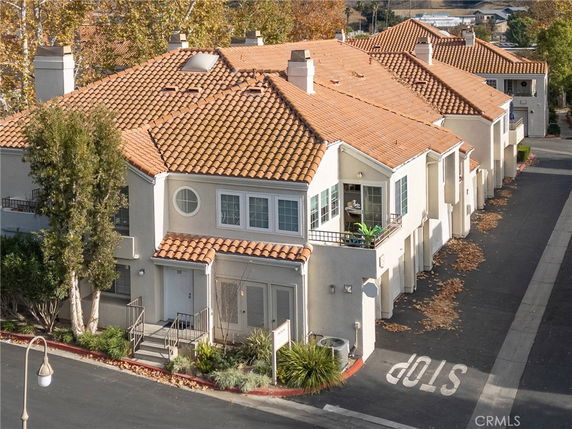 Front view of a two-story house with a tiled roof and balconies.