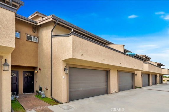 Front view of a residential building with multiple garages and two entry doors.
