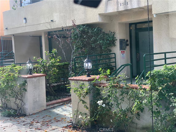 Front view of a building with greenery and a pathway.