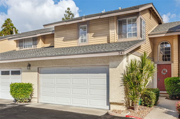 Front view of a two-story house with a double garage and a red front door.
