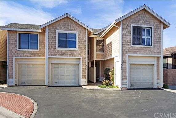 Front view of a multi-story house with three garage doors.