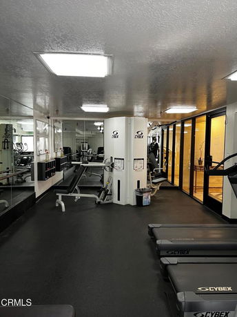 Interior view of a fitness gym with exercise machines and mirrored walls.