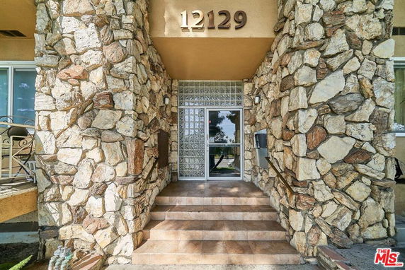 Front entrance of a building with stone facade and glass door.