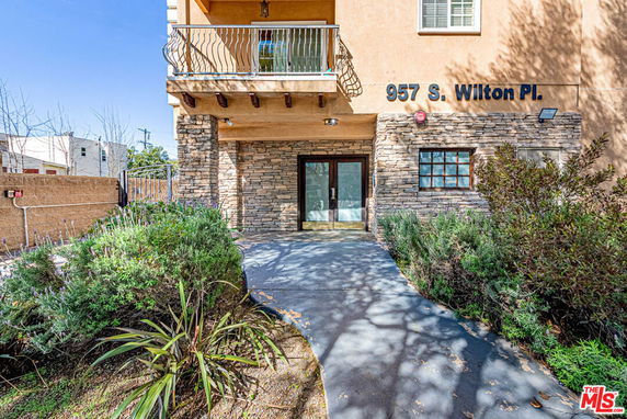 Front view of a building entrance with stone facade and walkway.