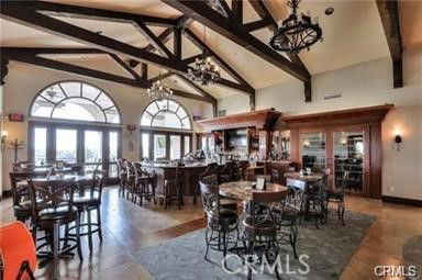 Interior view of a clubhouse with tables, chairs, and a bar area.