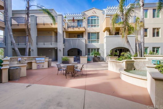 View of a multi-story building courtyard with balconies and outdoor seating.