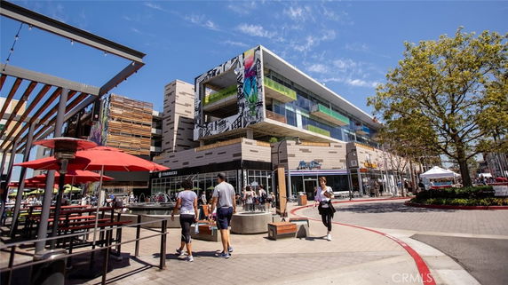 Front view of a modern multi-story commercial building with shops at the ground level.