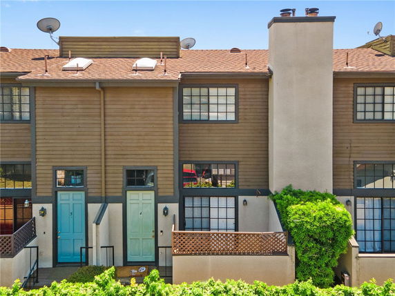 Front view of a two-story townhouse with multiple entrances and large windows.
