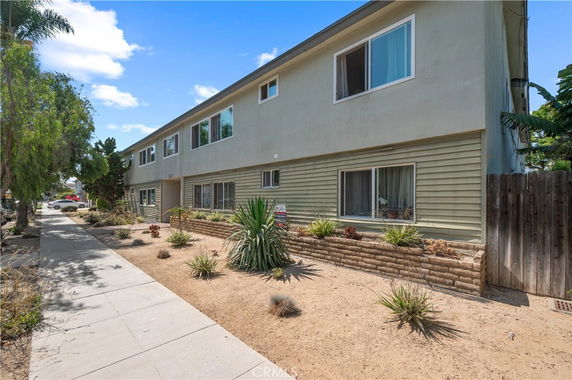 Front view of a two-story building with a landscaped front yard.
