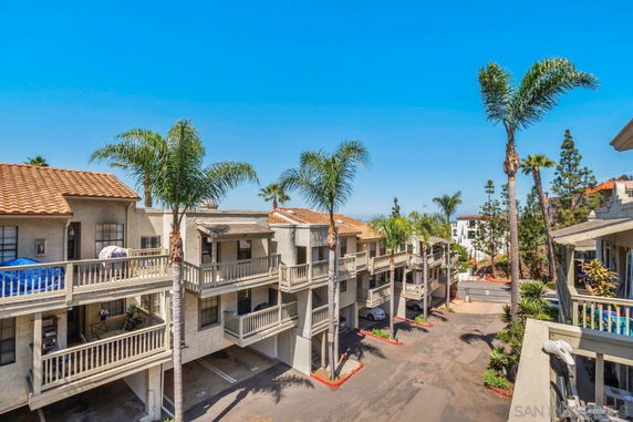 View of multi-story apartment buildings with balconies and parking spaces below.