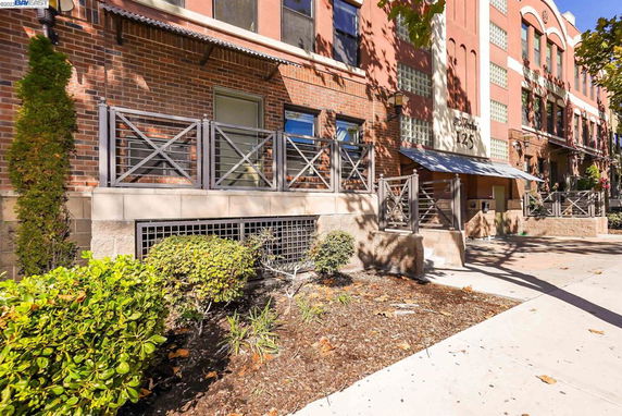 Front view of a building with brick facade and metal railings.
