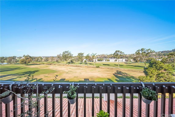 Wide view of a landscape with open fields and distant trees seen from a building.