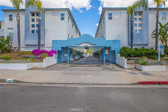 Front view of a multi-story residential building with gated entrance.