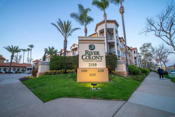 Front view of a multi-story condominium building with palm trees.