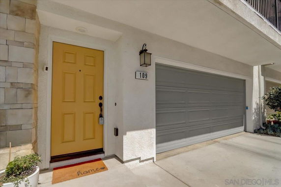 Front view of a house with a yellow front door and a double garage.