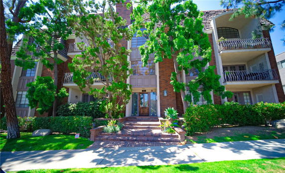 Front view of a multi-story building with balconies and a brick facade.