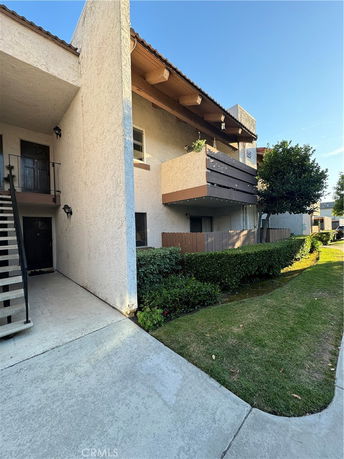 Front view of a multi-story building with a balcony and staircase.