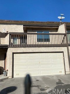 Front view of a house with a double garage and balcony.