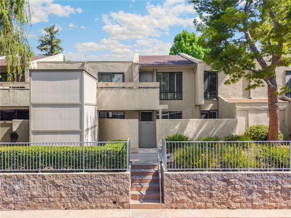 Front view of a two-story residential building with a gated entrance.