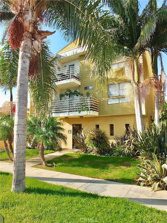 Front view of a multi-story building with balconies and yellow exterior.