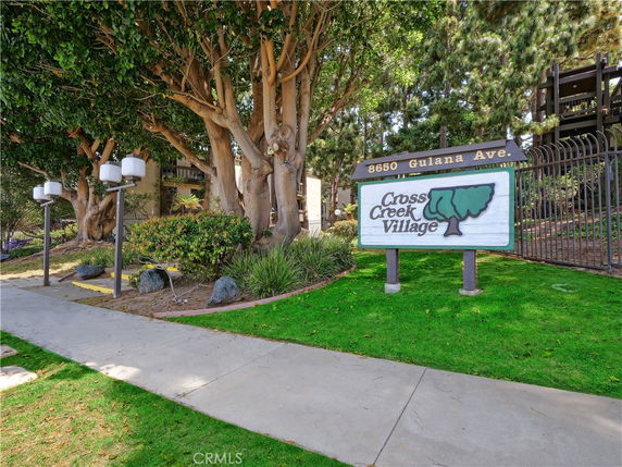 Entrance view of Cross Creek Village with signage and walkway.