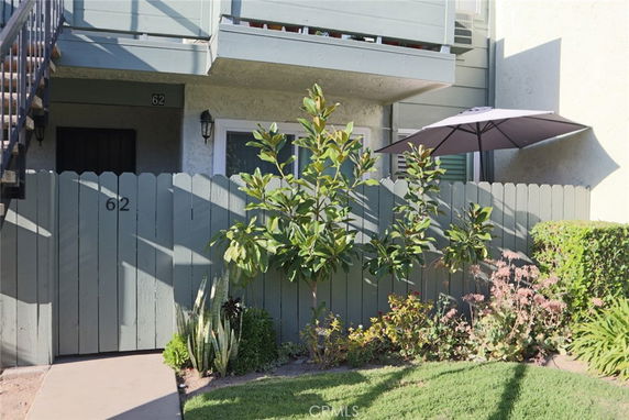 Front view of a two-story building with a small fenced garden area.