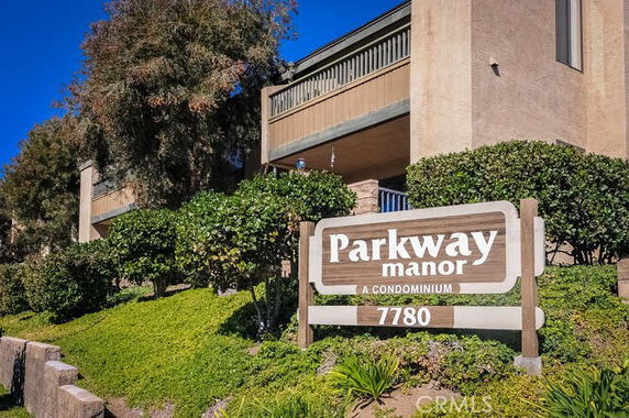 Front view of a condominium building with a sign reading 'Parkway Manor.'