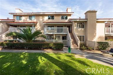Front view of a two-story residential building with balconies and tile roofing.