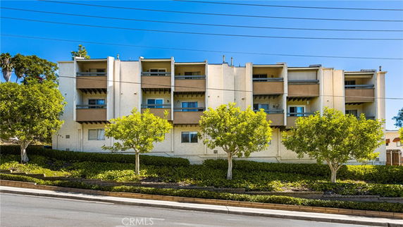 Front view of a multi-story apartment building with balconies.
