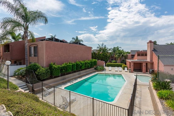 Outdoor swimming pool area with surrounding buildings.