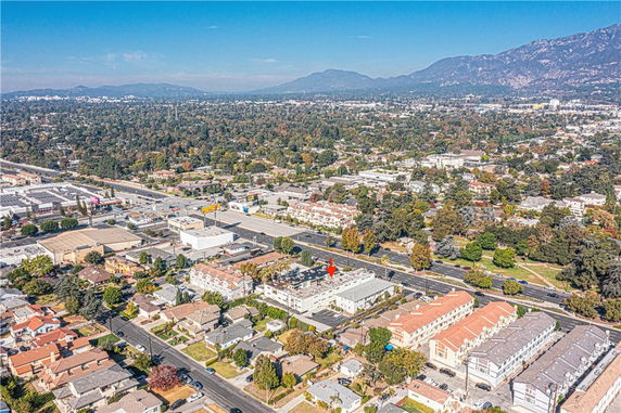 Panoramic aerial view of a residential and commercial area with roads and surrounding landscape.