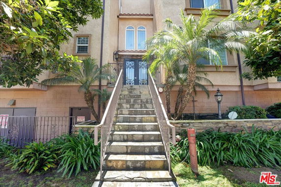 Front view of a multi-story building with a staircase leading to the entrance.
