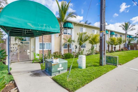Front view of a two-story residential building with green awnings.