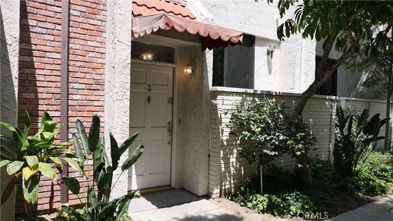 Front view of a building entrance with a white door and brick exterior.