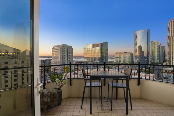 View from a balcony overlooking a cityscape with high-rise buildings.