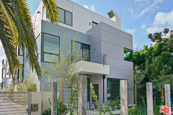 Front view of a modern two-story house with large windows and balcony.
